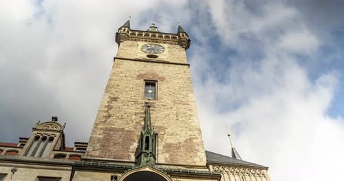 Die Prager Rathausuhr auf dem Alten Rathaus im Zeitraffer zierlich sich schnell bewegenden Wolken im Hintergrund