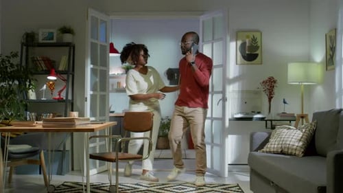 Woman Showing Phone to Man in Living Room