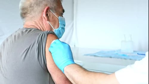 Senior Man Receives Vaccination in Medical Setting