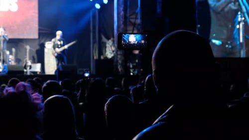 People Filming Rock Concert on Smartphones Silhouettes Crowd of Fans Dancing