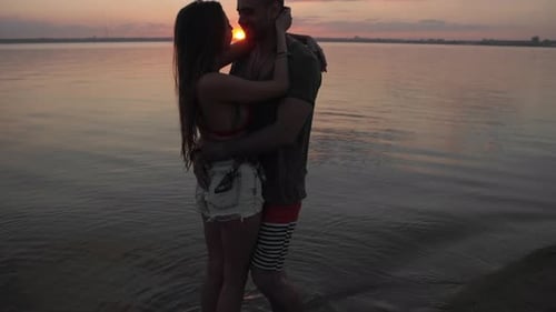 Paar küsst sich am Strand bei Sonnenuntergang