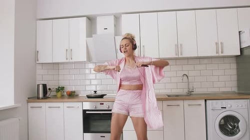Woman Dancing to Music in Bright Kitchen