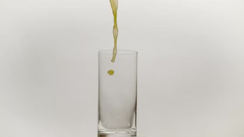 Pouring Yellow-Green Liquid into a Glass