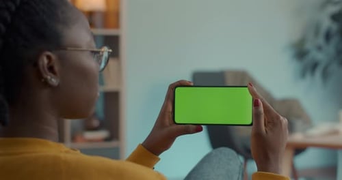 African American Woman Holding Smartphone with Green Screen