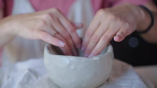 Young Adult Forming Gray Clay into a Bowl