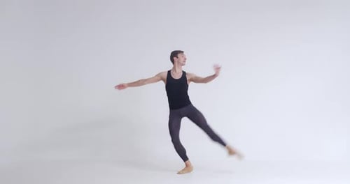 Elegant Male Ballet Dancer Performs Acrobatic Elements and Pirouette Ballet Dance on a White