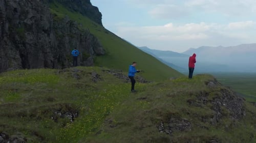 Hikers Exploring Grassy Hillside on Sunny Day