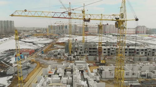 Bewegung über der Baustelle mit riesigen gelben Kränen