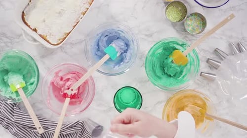 Flat lay. Mixing food coloring into Italian buttercream frosting.