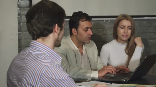 Business Team Collaborating on Laptop at Desk