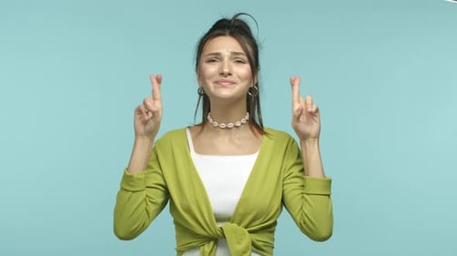 Young Woman Crossing Fingers Hoping For Good Luck