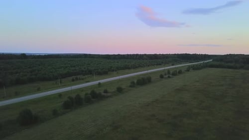 Flying Over a Countryside Road and Green Fields Aerial View