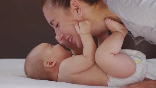Close Up Mother Kissing Happy Baby Laughing Enjoying Loving Mom Nurturing Toddler at Home.