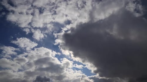Zeitraffer: Angespannte, flauschige Wolken bedecken die Sonne. Sonnenstrahlen brechen durch Wolken.