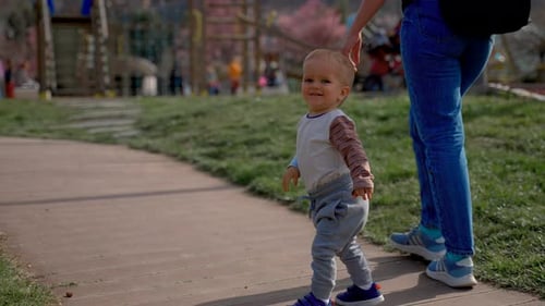 Cute Toddler Learns to Walk with Father on Wooden Road