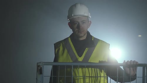 Serious Construction Worker Standing Guard at Night