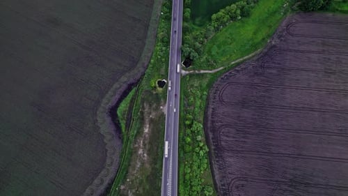 Autos fahren auf der rustikalen Asphaltstraße zwischen Feldern
