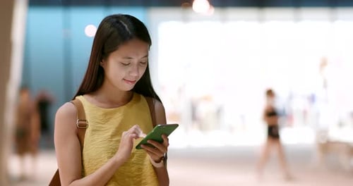 Woman use of mobile phone in the city at night