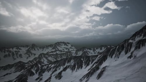 Dynamic Aerial Flyover of Snowy Mountain Peaks Under Overcast Sky