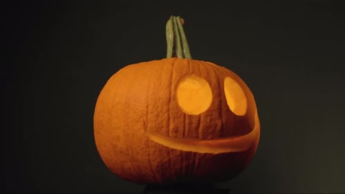 Pumpkin Head - Pumpkin With Carved Round Eyes And Mouth In Black Background. - close up, rotating le