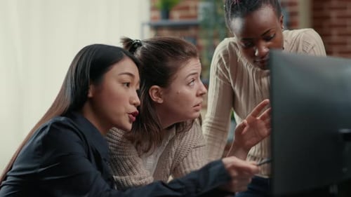 Engenheiro de software apontando para a tela do computador explicando o código em execução para o brainstorming de colegas