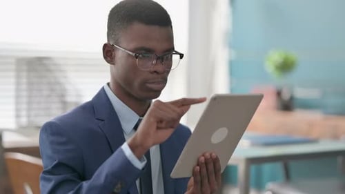 Young African Businessman Using Tablet in Office