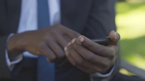 Close-up of African American Male Hands Using Smartphone. Unrecognizable Businessman Messaging