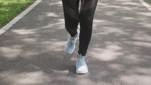 Closeup leg and foot of woman workout with jogging or running on summer in the park.