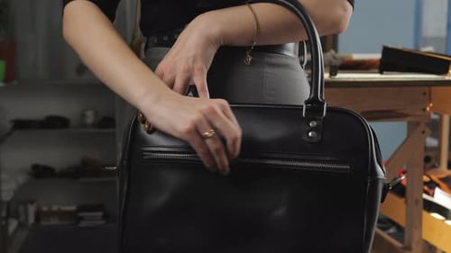 Girl in a Business Suit in the Workshop for Production of Leather Goods Demonstrates Black Women's
