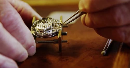 Close-up of horologist hands repairing a watch