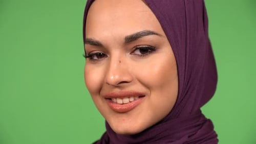 A Young Beautiful Muslim Woman Smiles at the Camera Face Closeup Green Screen Background