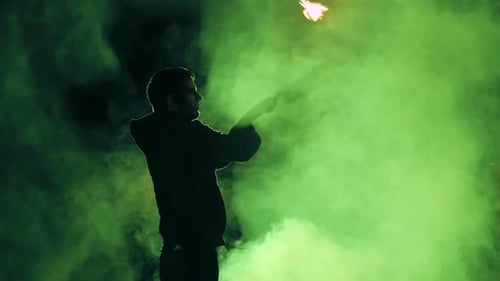 Performer Juggling Fire Torches in Smoky Night Scene