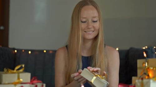 Woman Smiling Opening Gift at Christmas Party