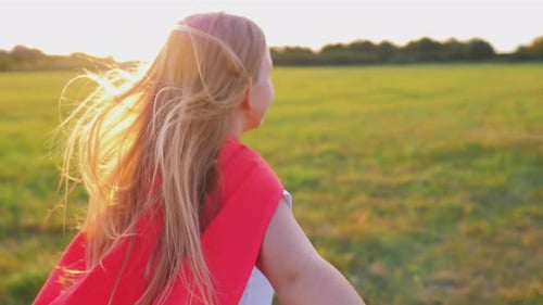 Happy Child Running in Field at Sunset