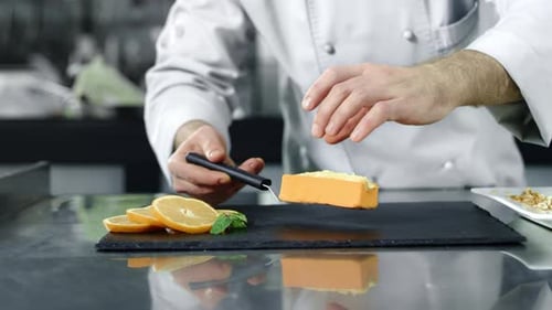 Chef Putting Desert on Board at Kitchen. Closeup Chef Hands Cooking Cake