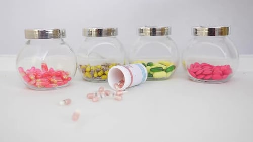 Pills Spill From Bottle Beside Jars