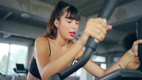 4K Portrait of Latin woman workout exercise on cycling machine at gym.