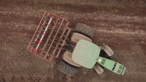 a Large Tractor Plows a Field