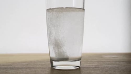Effervescent Tablet Dissolving Rapidly in a Glass of Water
