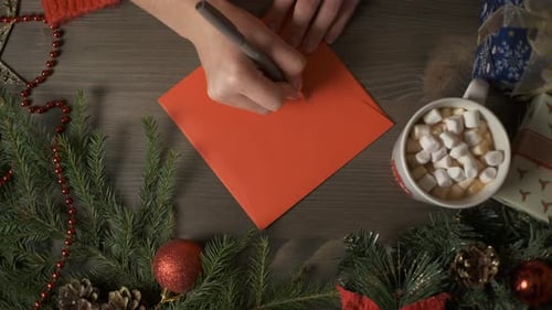 Writing Christmas Card with Decorations Overhead Shot
