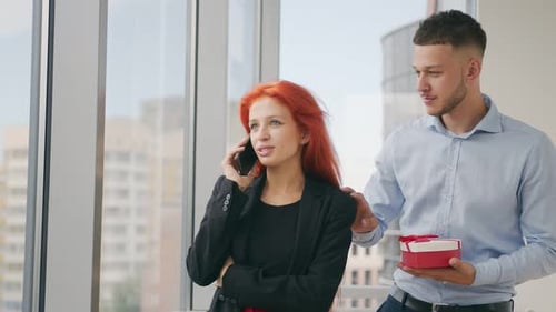 Man Surprises Woman with Gift in Office