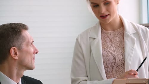 Two Business People Talk Project Strategy at Office