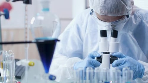 Scientist Examines Sample with Microscope in Laboratory