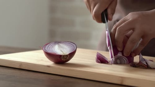 Slicing a Red Onion on Wooden Cutting Board