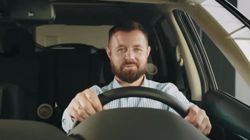 Man Smiling From Inside a Car in Dealership