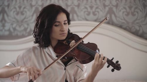 Woman Plays Violin in Bedroom