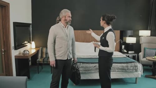 Hotel Manager Showing Guest Man around Room