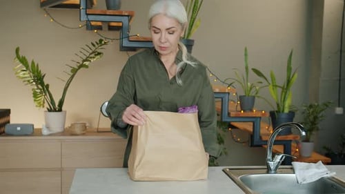 Woman Unpacking Groceries in Modern Kitchen