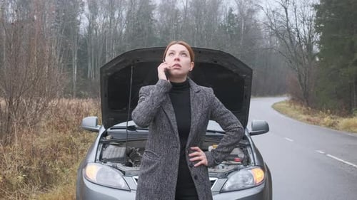 Woman Talking on Phone in Front of Car