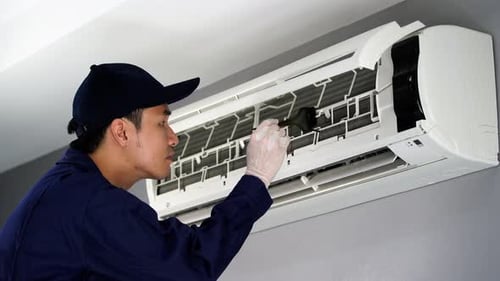 technician service cleaning the air conditioner indoors